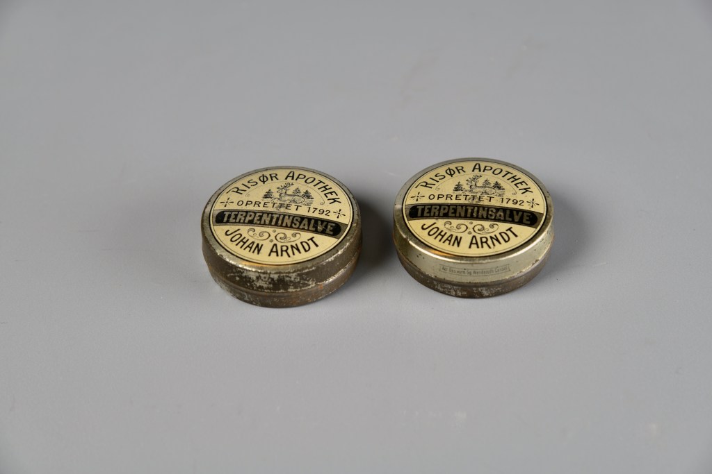To gamle bokser med terpentinsalve frå Risør Apotek, oppretta 1792, med påskrift av Johan Arndt.